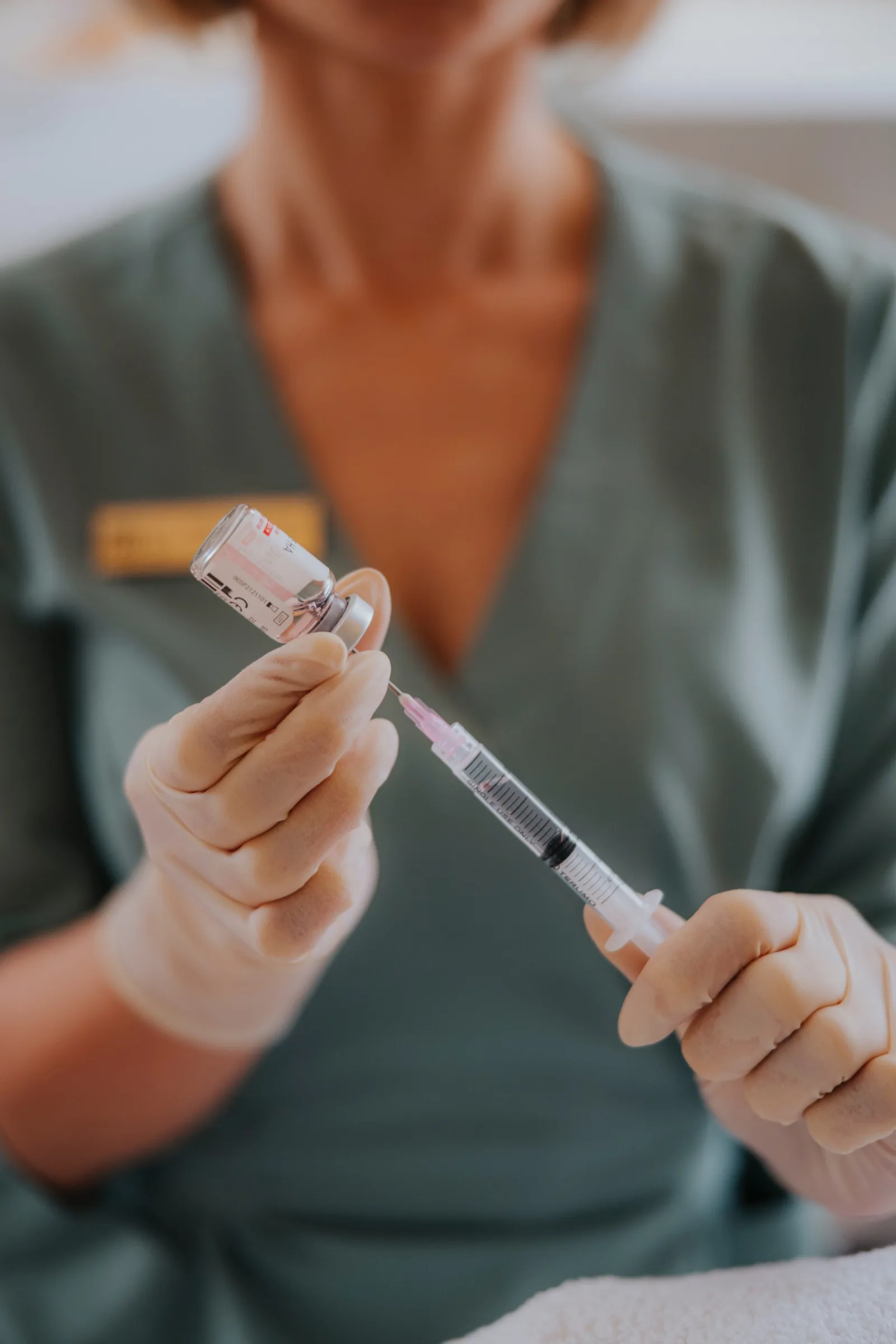 Kosmetolog nabiera do strzykawki spersonalizowany koktajl mezoterapeutyczny z ampulki