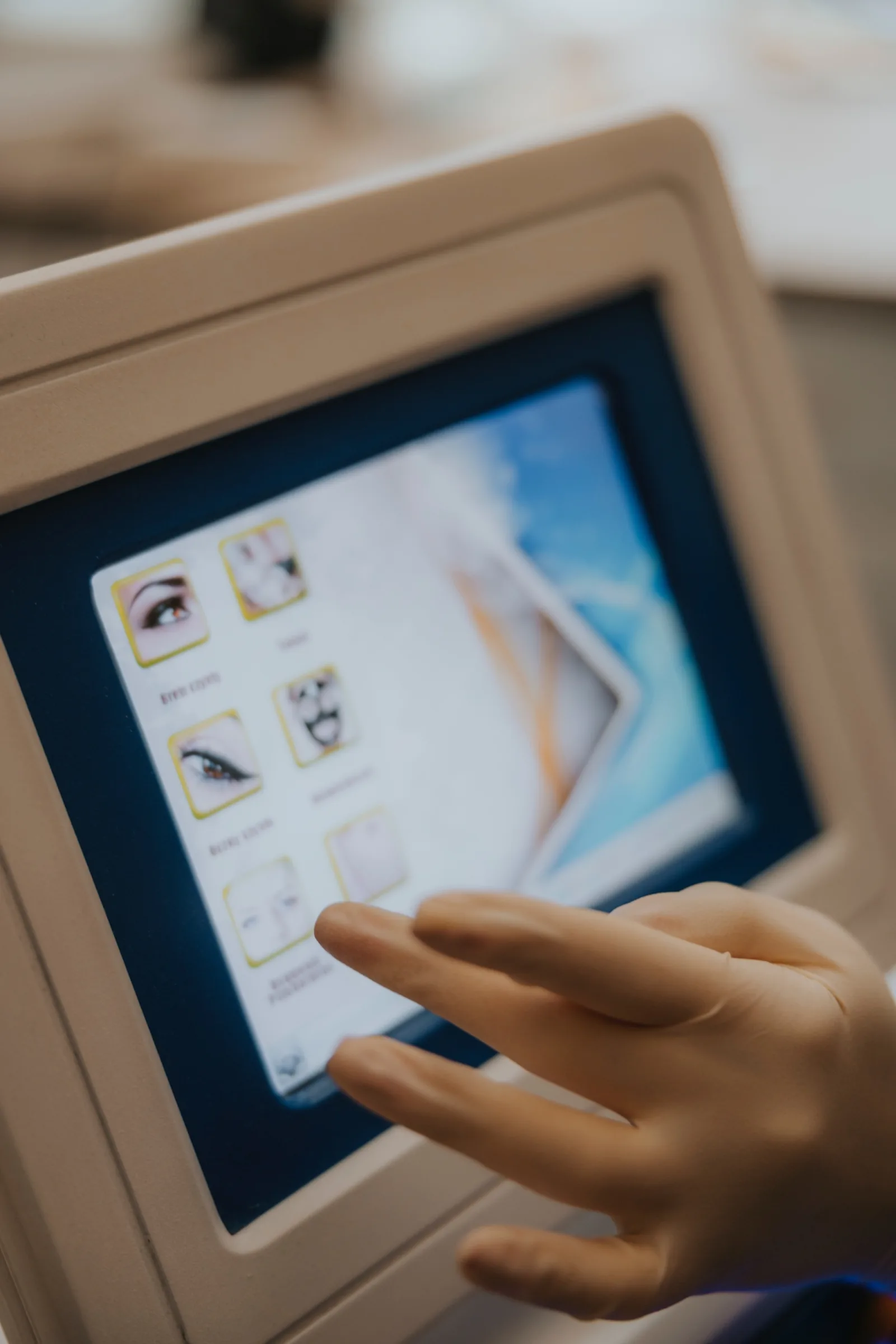 Hand selecting a pigment removal programme on the touchscreen of the laser device