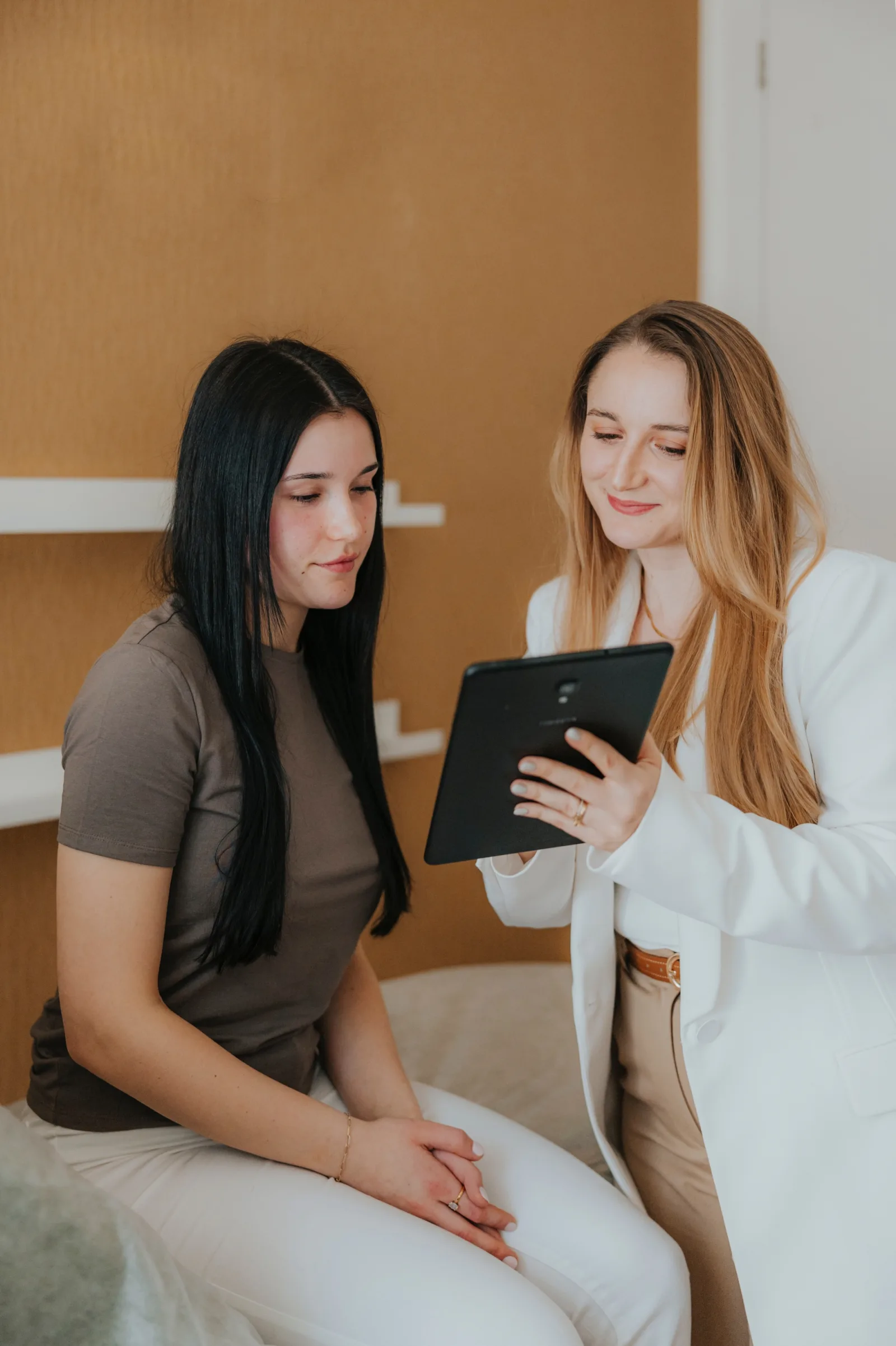 Specjalistka w białej marynarce omawia z klientką Beauty Plan na tablecie podczas konsultacji w Face and Body Institute